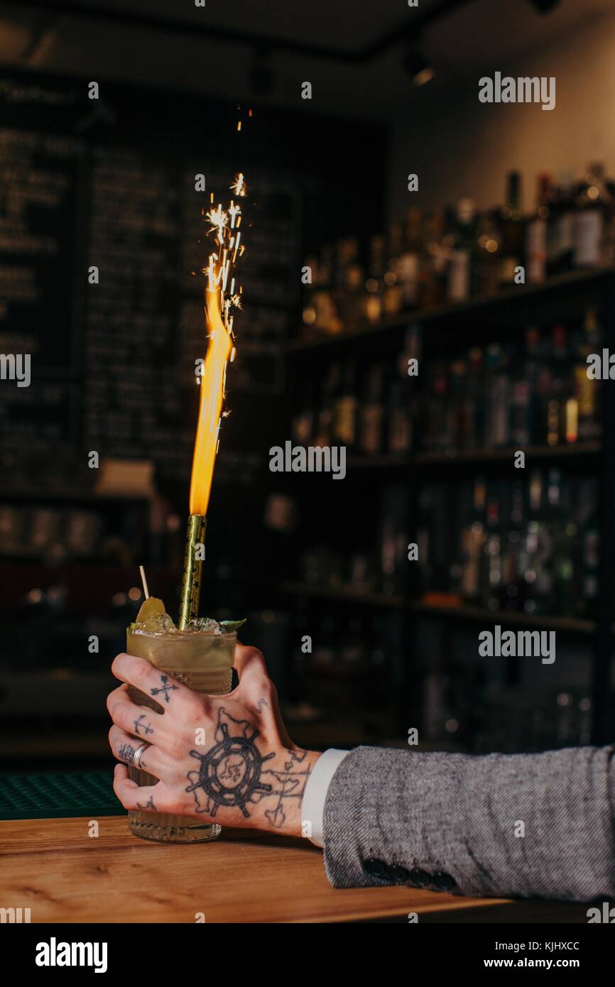 Man's hand reaching for a cocktail in a bar Stock Photo