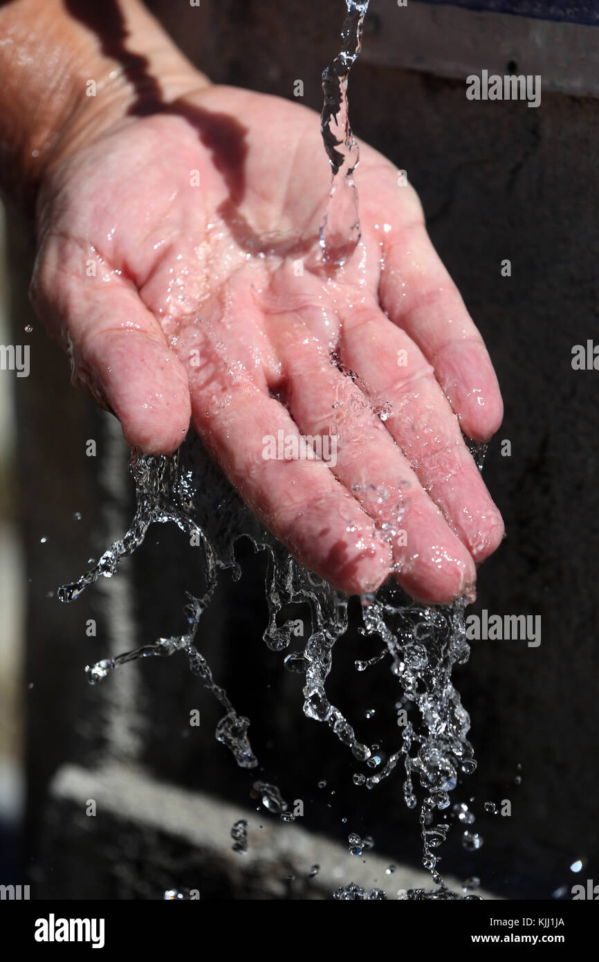 Hand in water fountain. Close-up.  France. Stock Photo