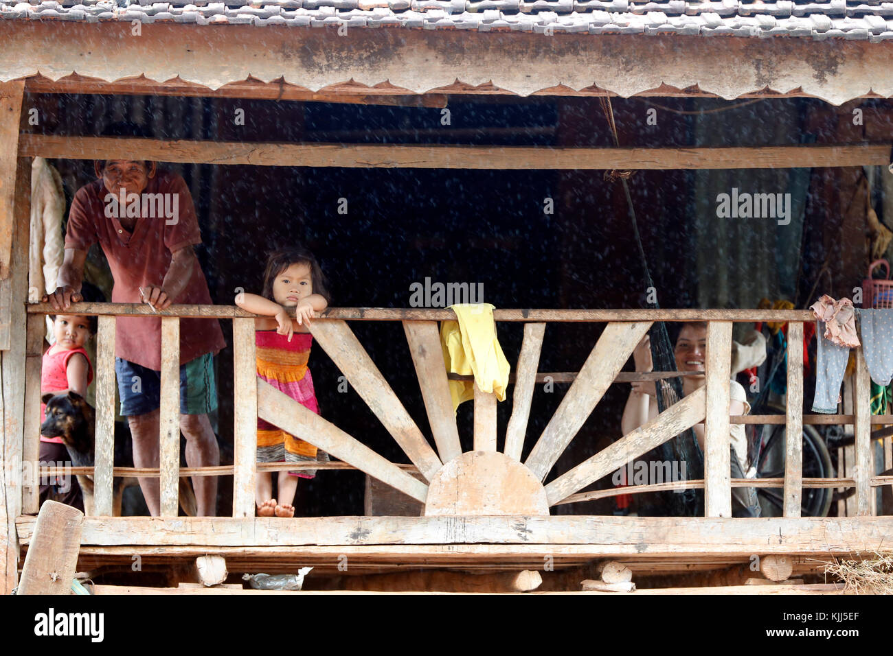Jarai (Gia Rai) ethnic group. A family  inside their traditional home during the monsoon.  Kon Tum. Vietnam. Stock Photo