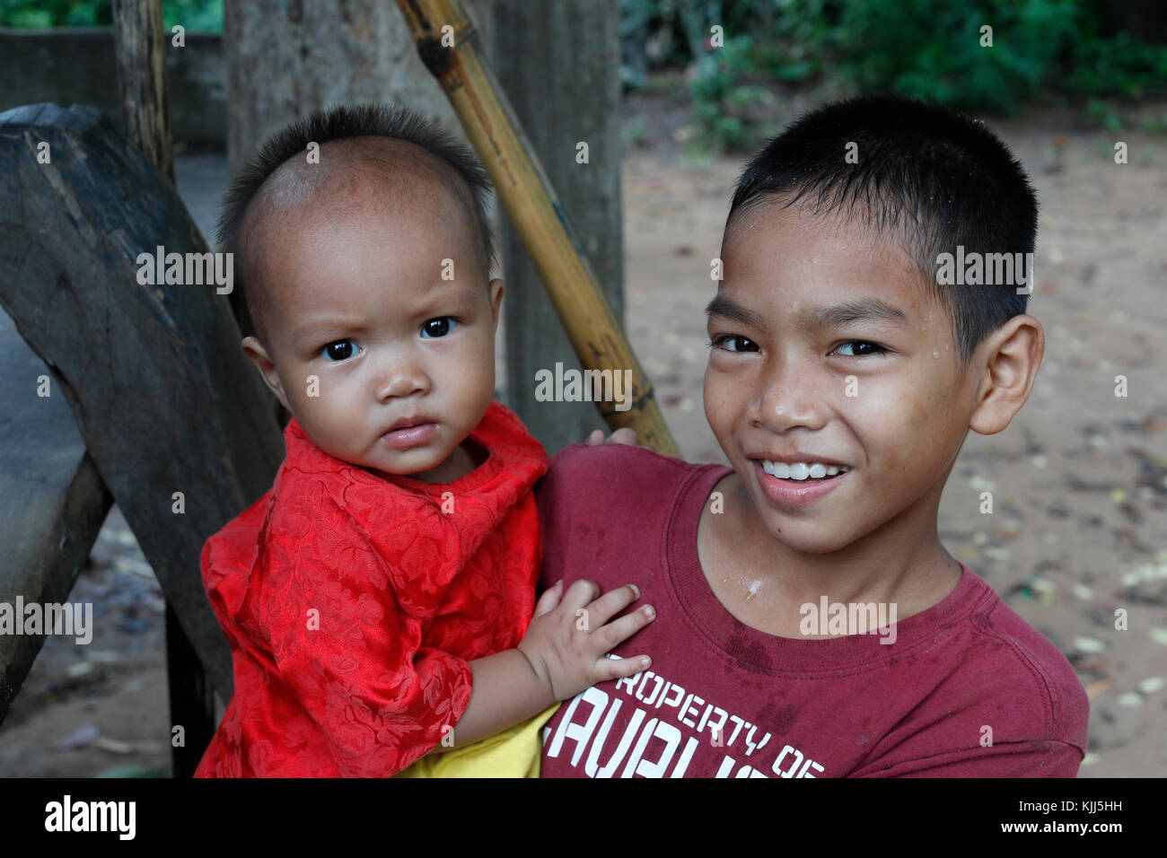 Bahnar (Ba Na) ethnic group. Young boy carrying baby in his back.  Kon Tum. Vietnam. Stock Photo