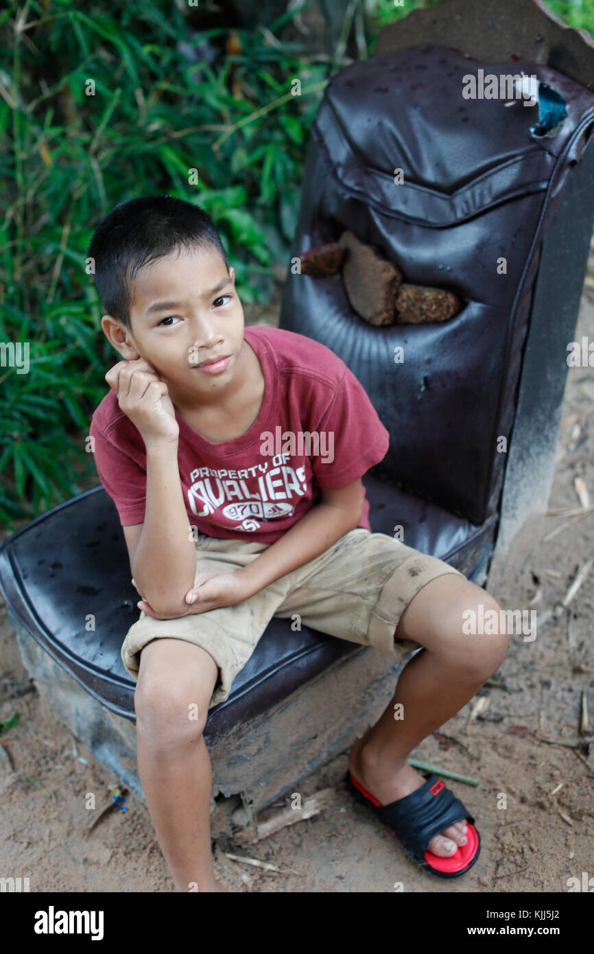 Bahnar (Ba Na) ethnic group.  Young boy sitting on an old chair.  Kon Tum. Vietnam. Stock Photo