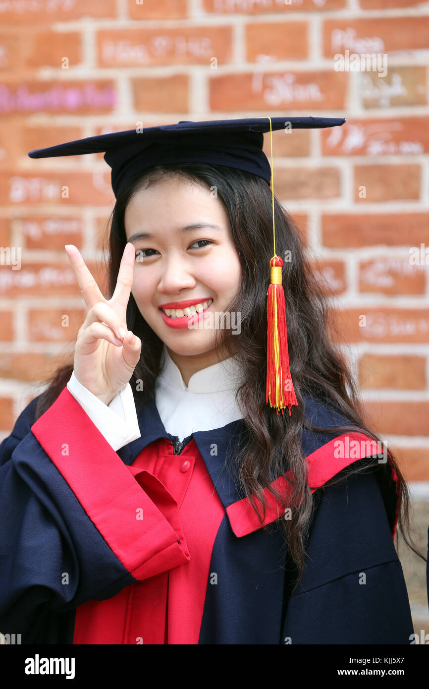 Young Asian university student wearing cap and gown.  Ho Chi Minh City.  Vietnam. Stock Photo