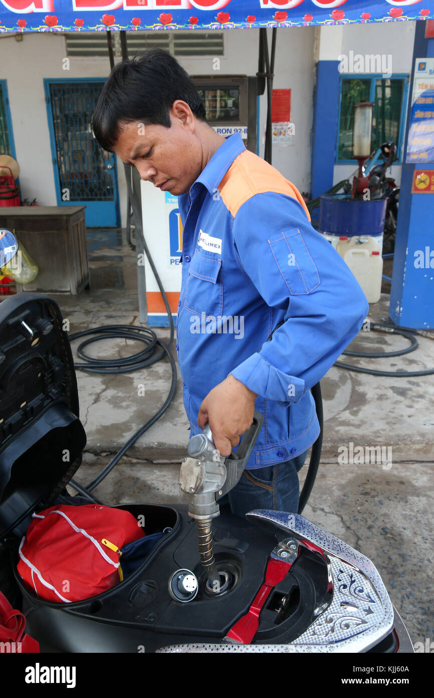 Gas station attendant filling up a motor scooter.  Thay Ninh. Vietnam. Stock Photo