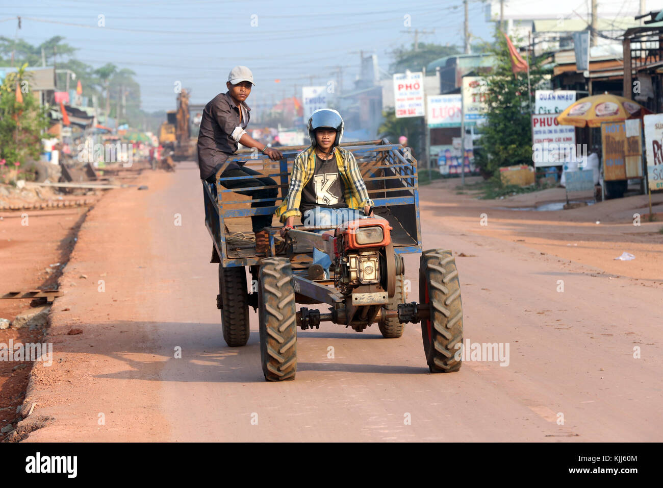 Men travelling on tractor. Thay Ninh. Vietnam. Stock Photo