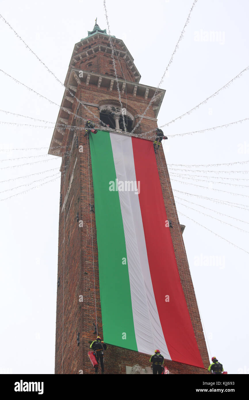 Vicenza, VI, Italy - December 4, 2015: Firefighters with a big italian flag and the tower of ancient Palace called Basilica Palladiana during an exerc Stock Photo