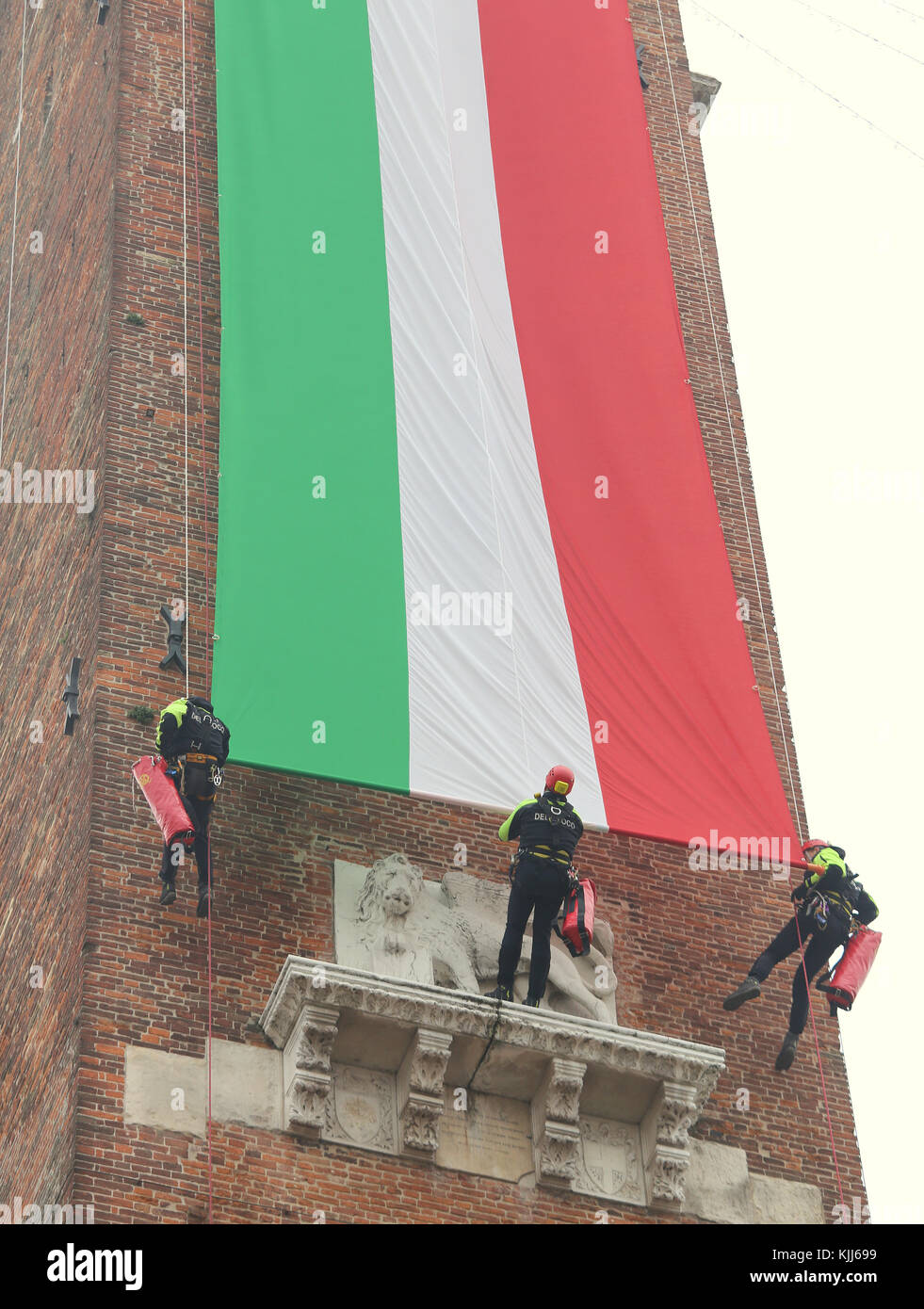 Vicenza, VI, Italy - December 4, 2015: Firefighters with a big italian flag on an ancient Palace called Basilica Palladiana during an exercise Stock Photo