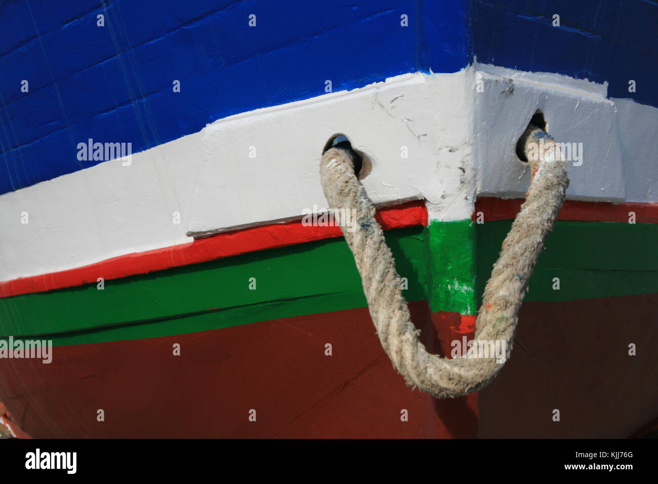 detail of the front of a colored wooden boat wih a small rope Stock Photo