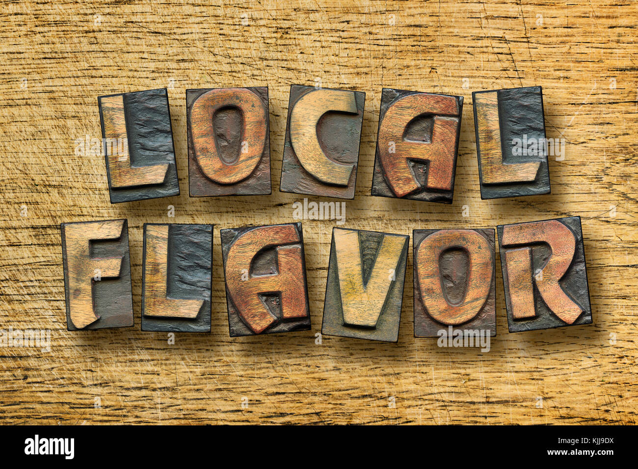 local flavor phrase assembled from scattered vintage letterpress blocks on scratched wooden background Stock Photo