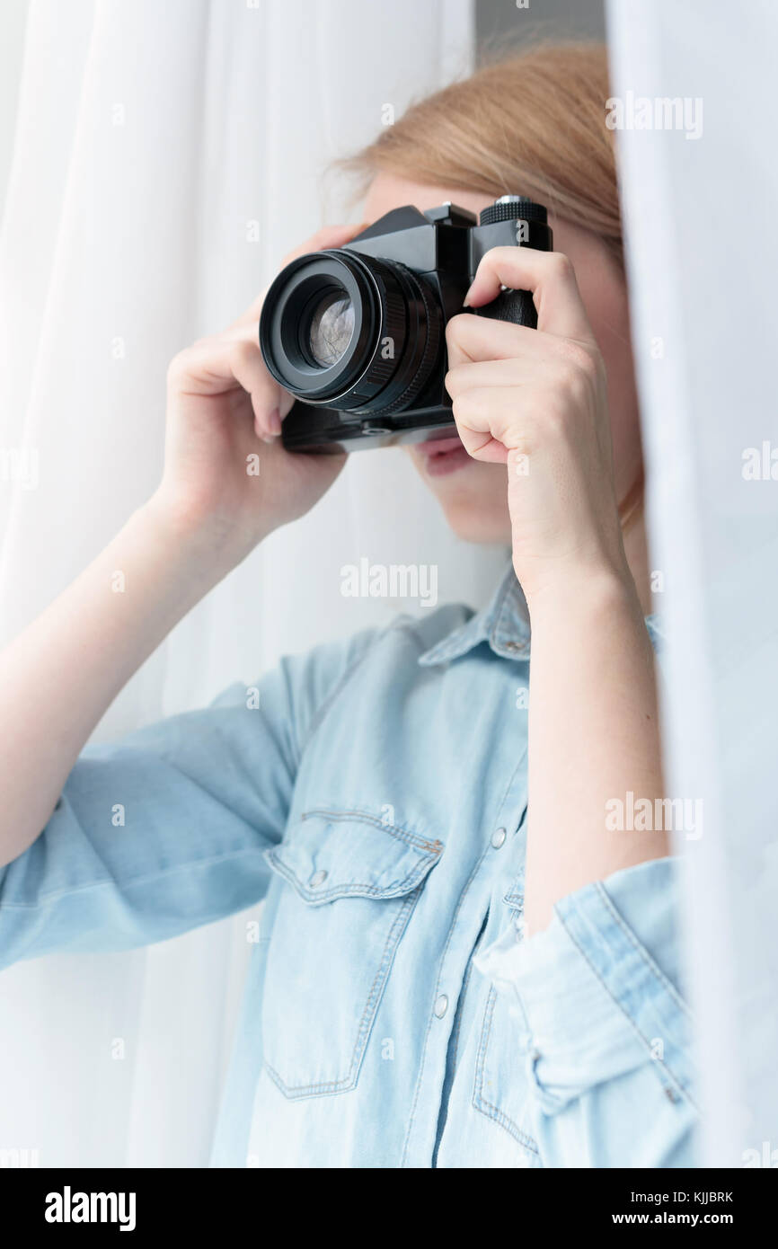 Woman taking pictures through the window Stock Photo