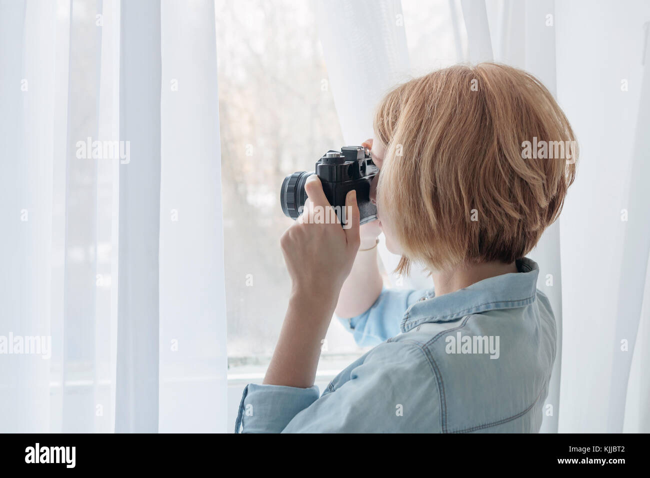 Woman taking photos through the window Stock Photo
