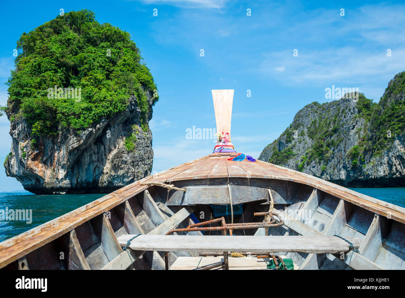 Traditional Thai wooden longtail boat with dramatic karst geography on the way to Maya Bay from Phi Phi Island Stock Photo