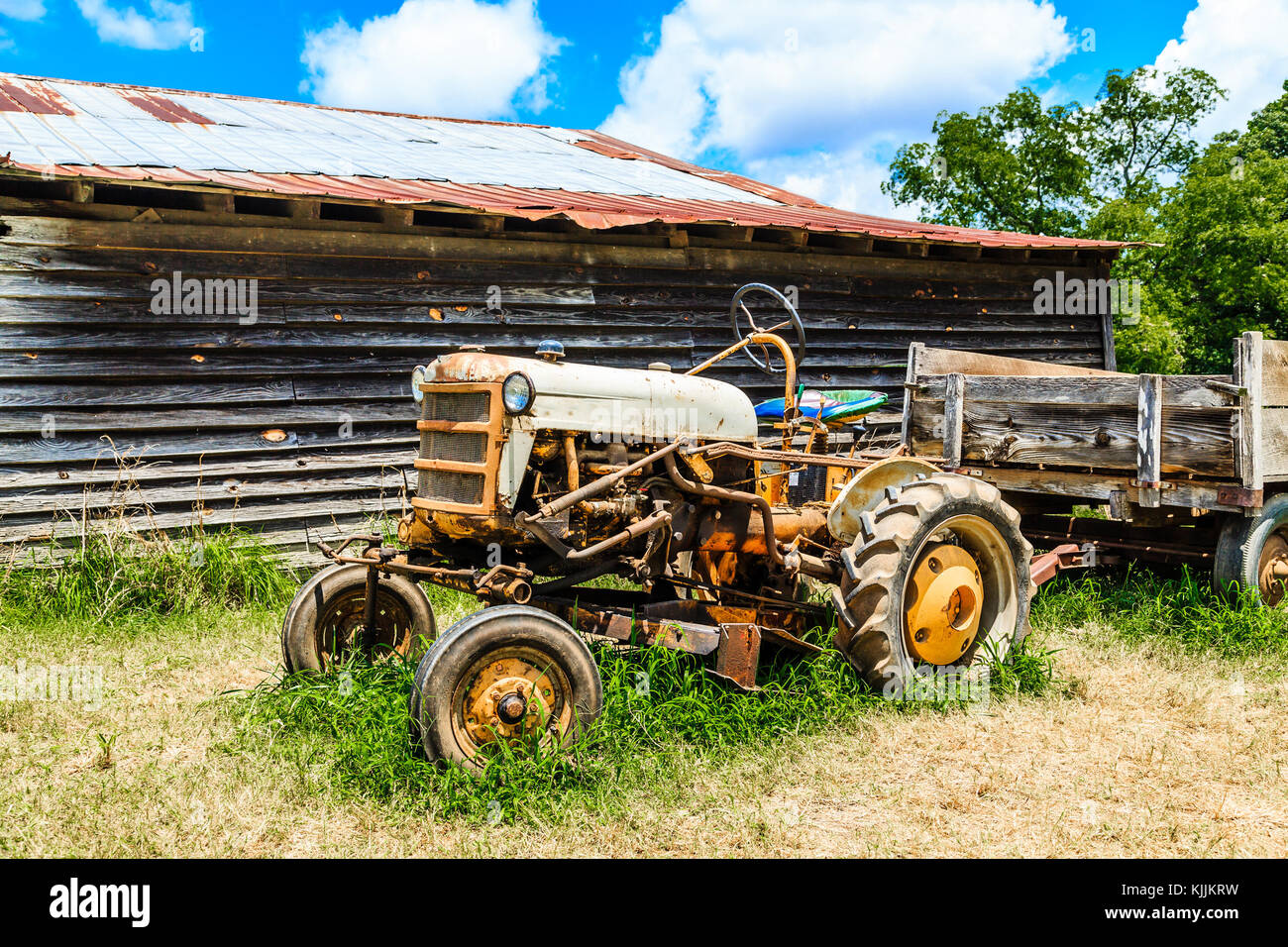 Old Tractor in a field by Wood Barn Stock Photo - Alamy