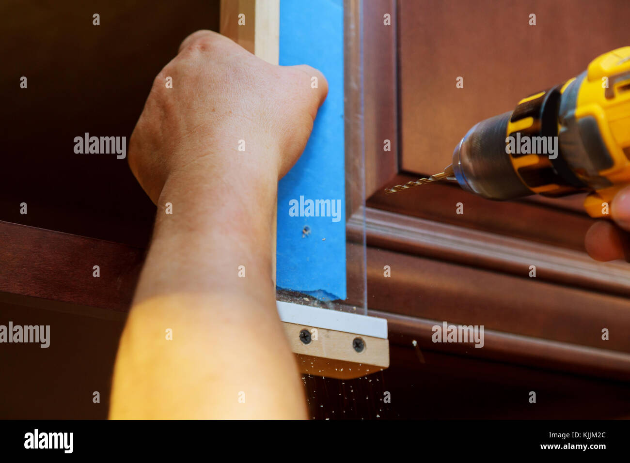 Installation of furniture hinges on the door master drills the