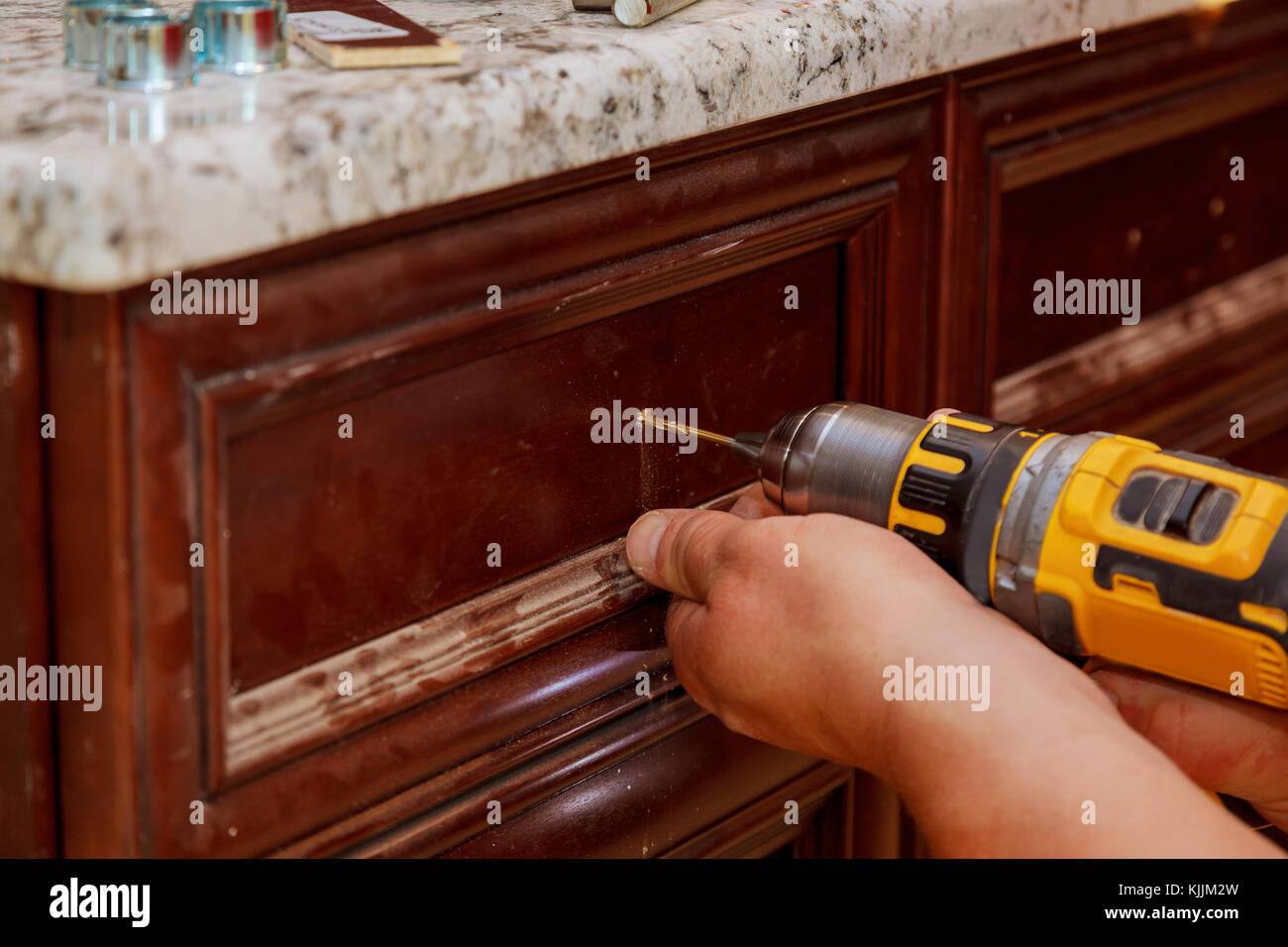 Installation of furniture hinges on the door master drills the