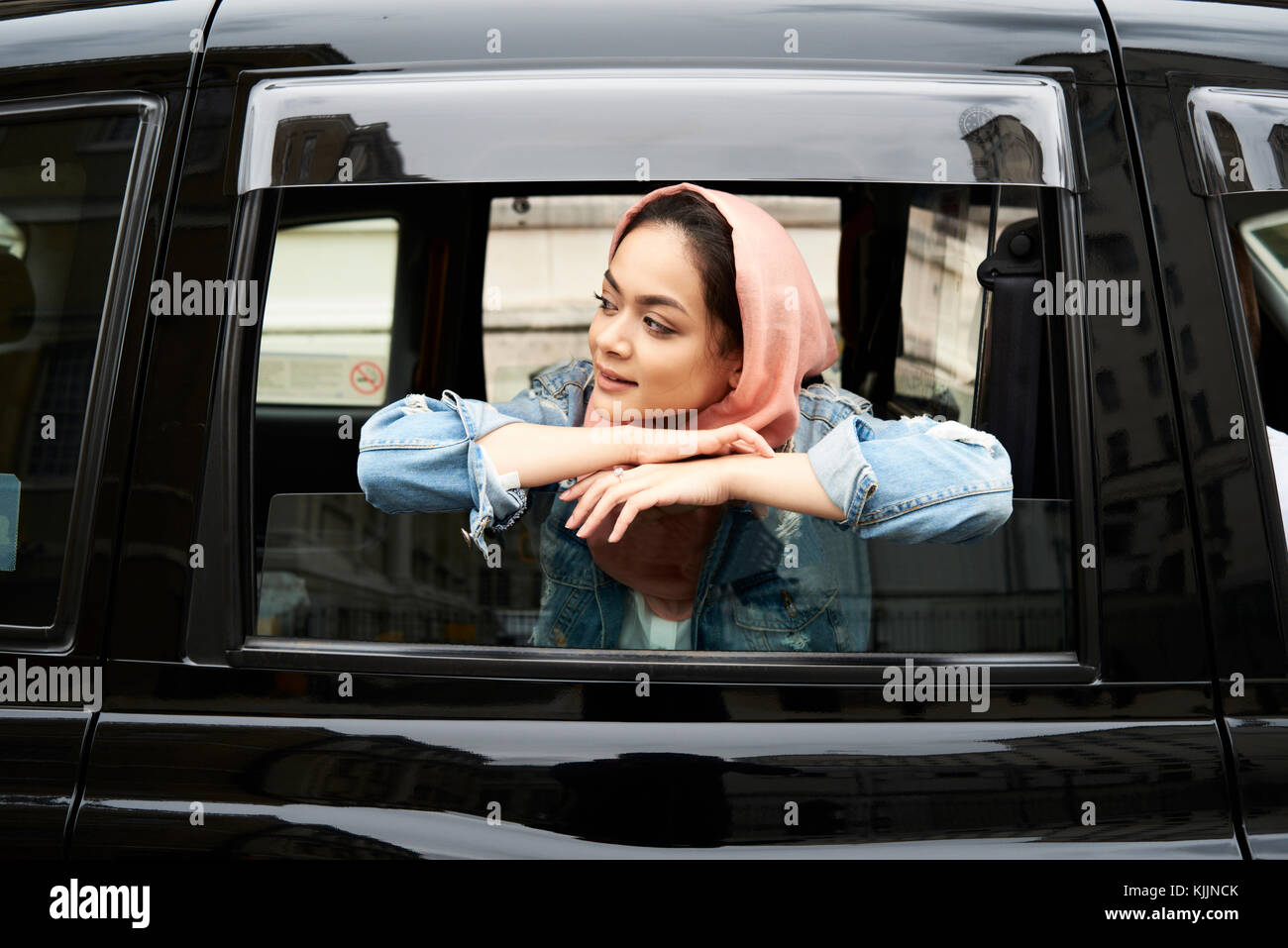 London, UK, England, Young student muslim girl wearing hijab amazed by city views from the window of a cab, muslim university student Stock Photo