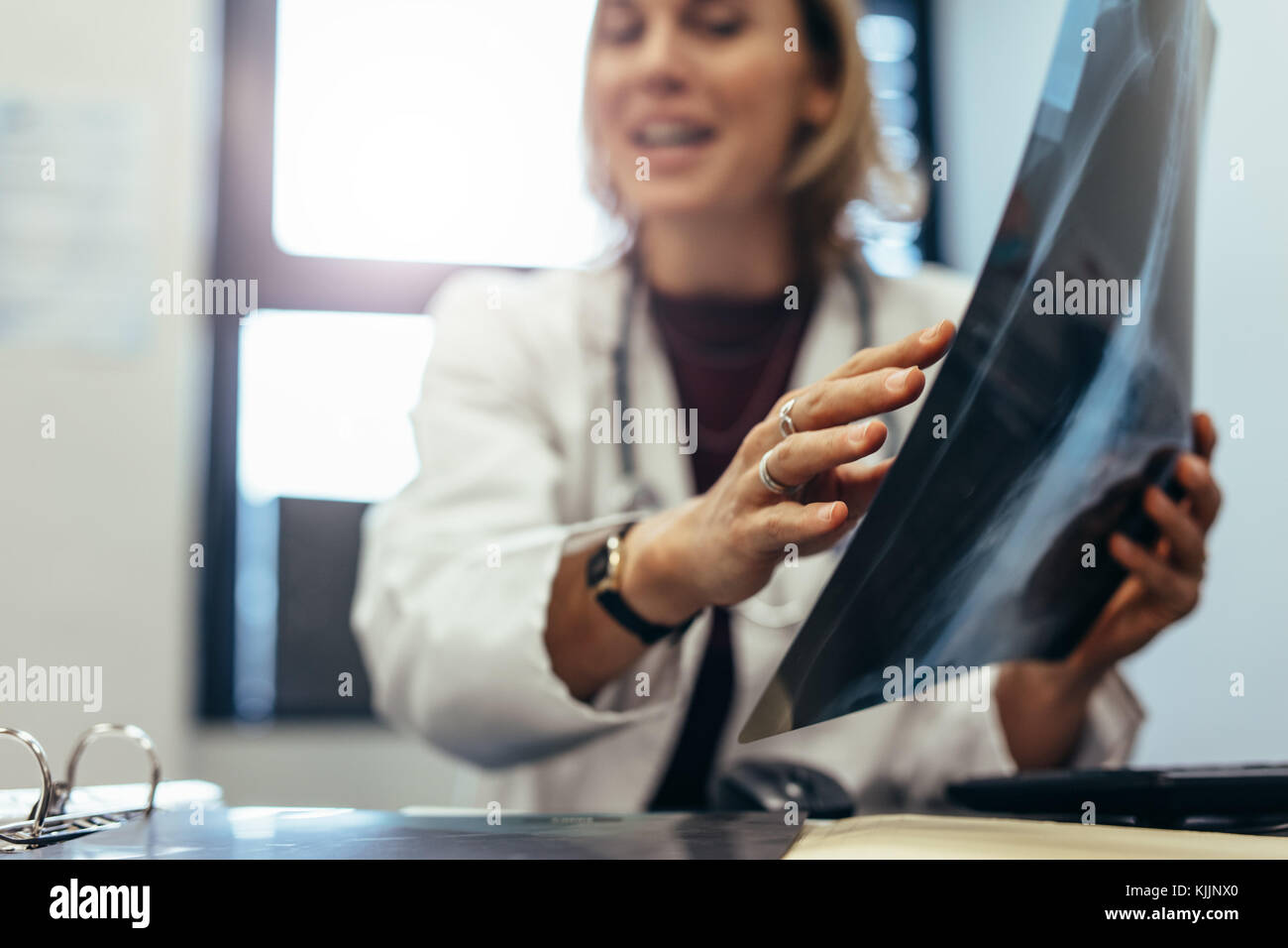 Medical doctor explaining medical scan result to patient in clinic. Medicine practitioner with x-ray discussing diagnosis. Stock Photo