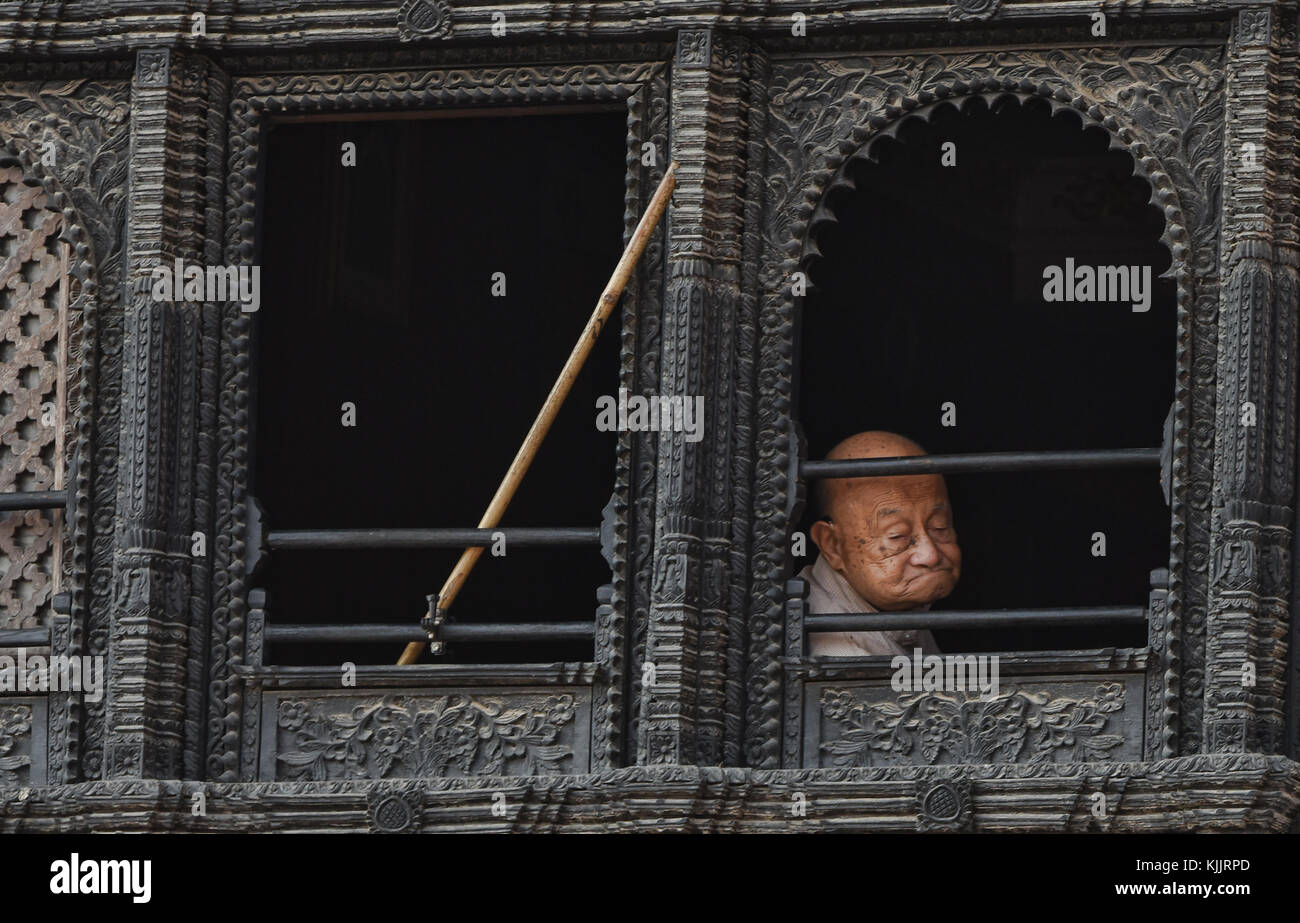 Man in the window of a Newari home, Boudhanath, Kathmandu, Nepal Stock Photo