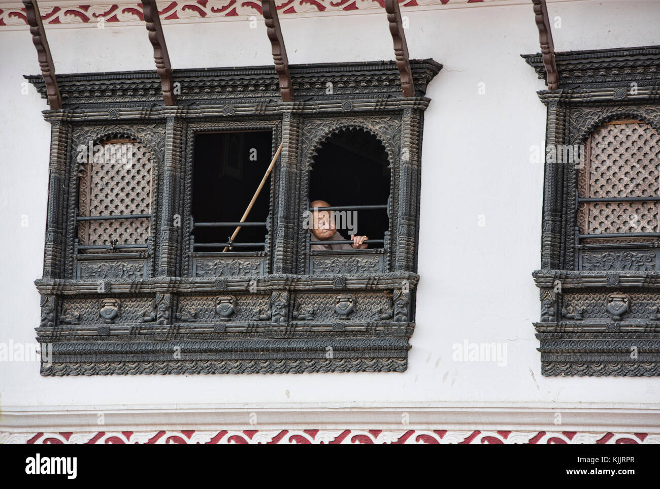Man in the window of a Newari home, Boudhanath, Kathmandu, Nepal Stock Photo