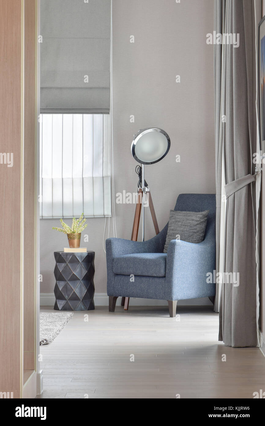 Deep blue armchair with stylish standing lamp in the corner of living