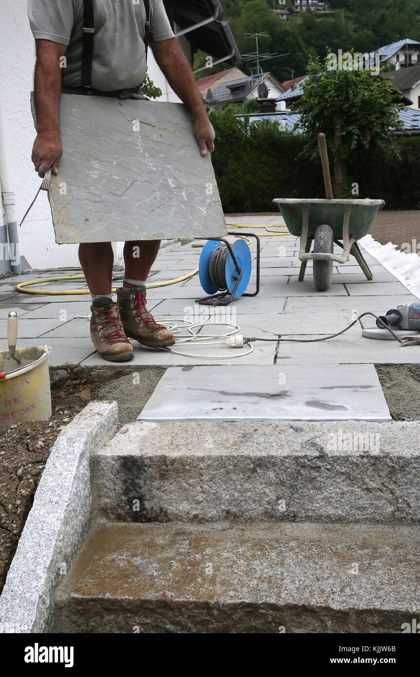 Construction site. Mason laying decorative natural stones.  France. Stock Photo