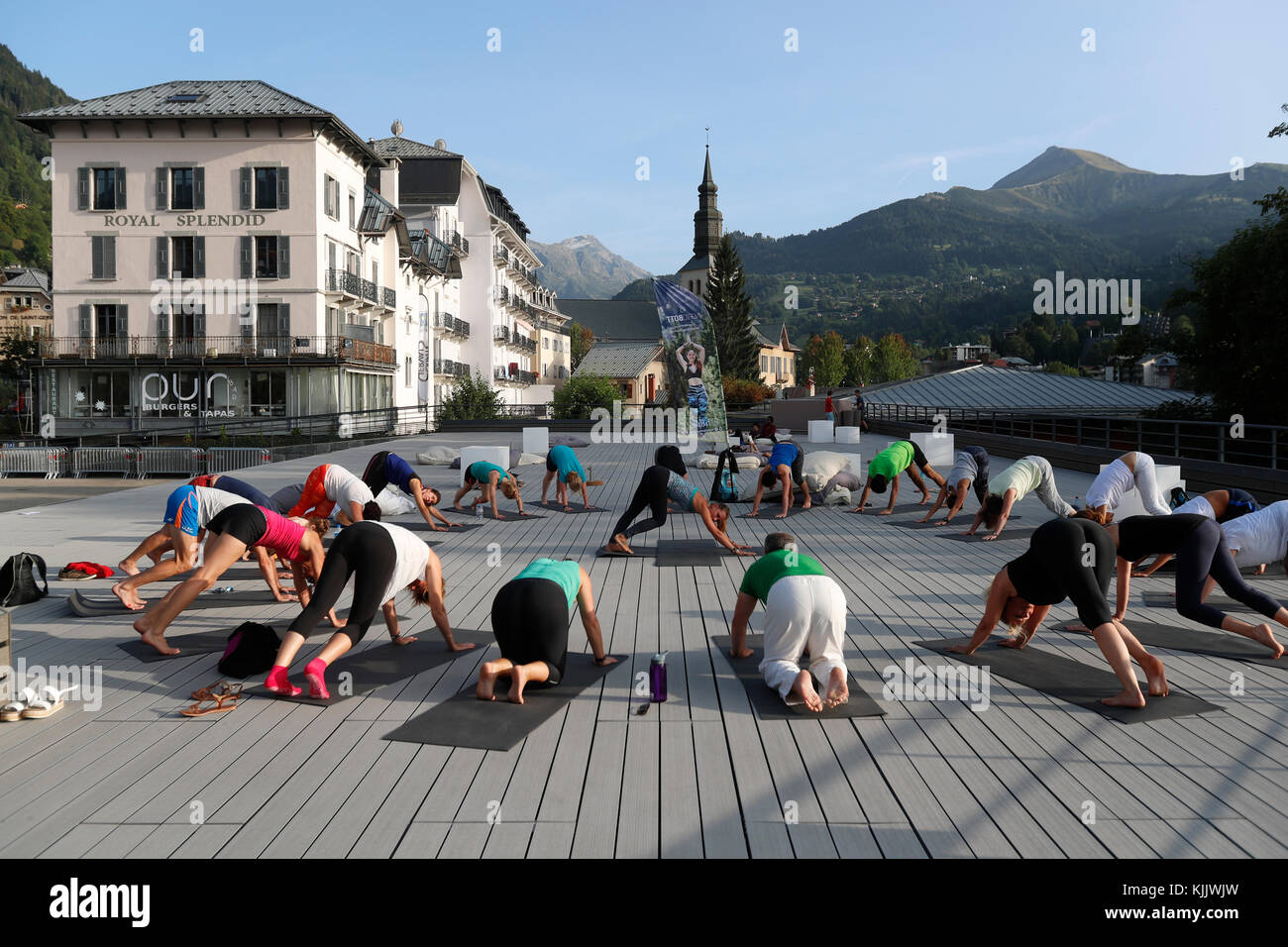 Outdoors large yoga class strecthing legs.  Saint-Gervais Mont-Blanc. France. Stock Photo