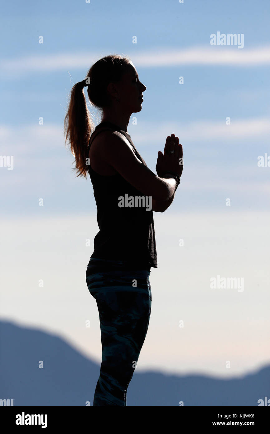A woman performs a Hatha Yoga pose on a mountain top. French Alps. France. Stock Photo