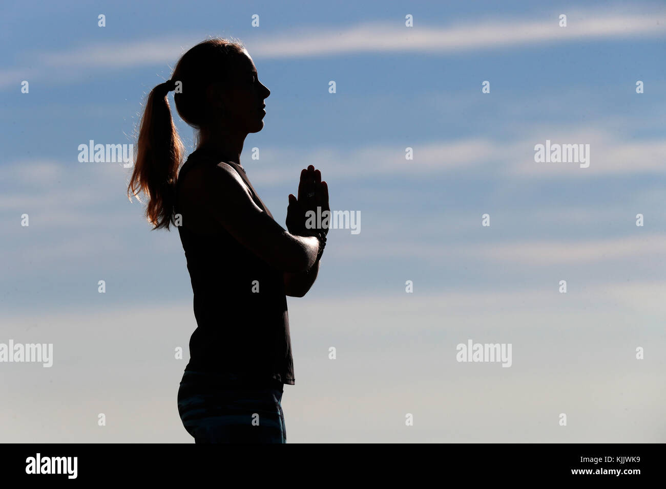 A woman performs a Hatha Yoga pose on a mountain top. French Alps. France. Stock Photo