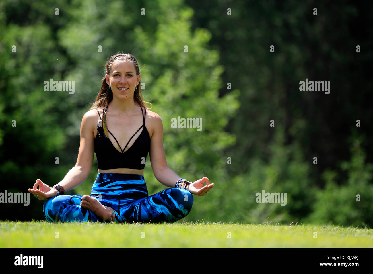 Woman doing yoga and meditation outside.  Lotus position.  Les Contamines. France. Stock Photo