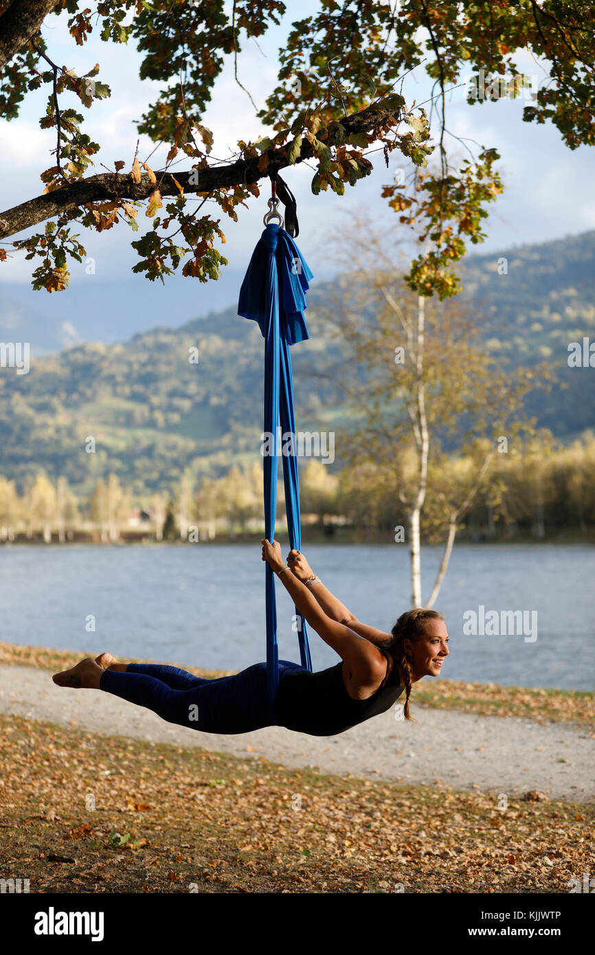 Woman doing pose of aerial yoga using hammock outdoors.  Saint-Gervais.  France. Stock Photo