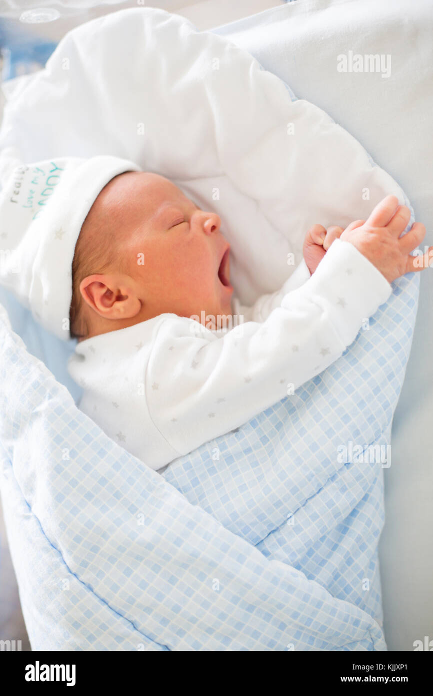 Beautiful newborn baby boy, laying in crib in prenatal hospital ...