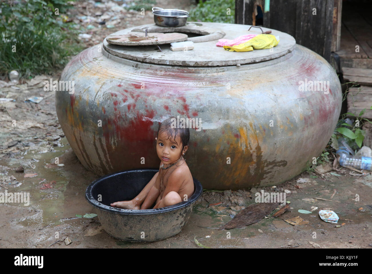 Baby bathing in a slum. Battambang.  Cambodia. Stock Photo