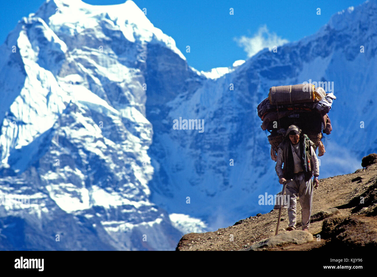 Sherpa carrying bags on an Everest trail. Nepal. Stock Photo