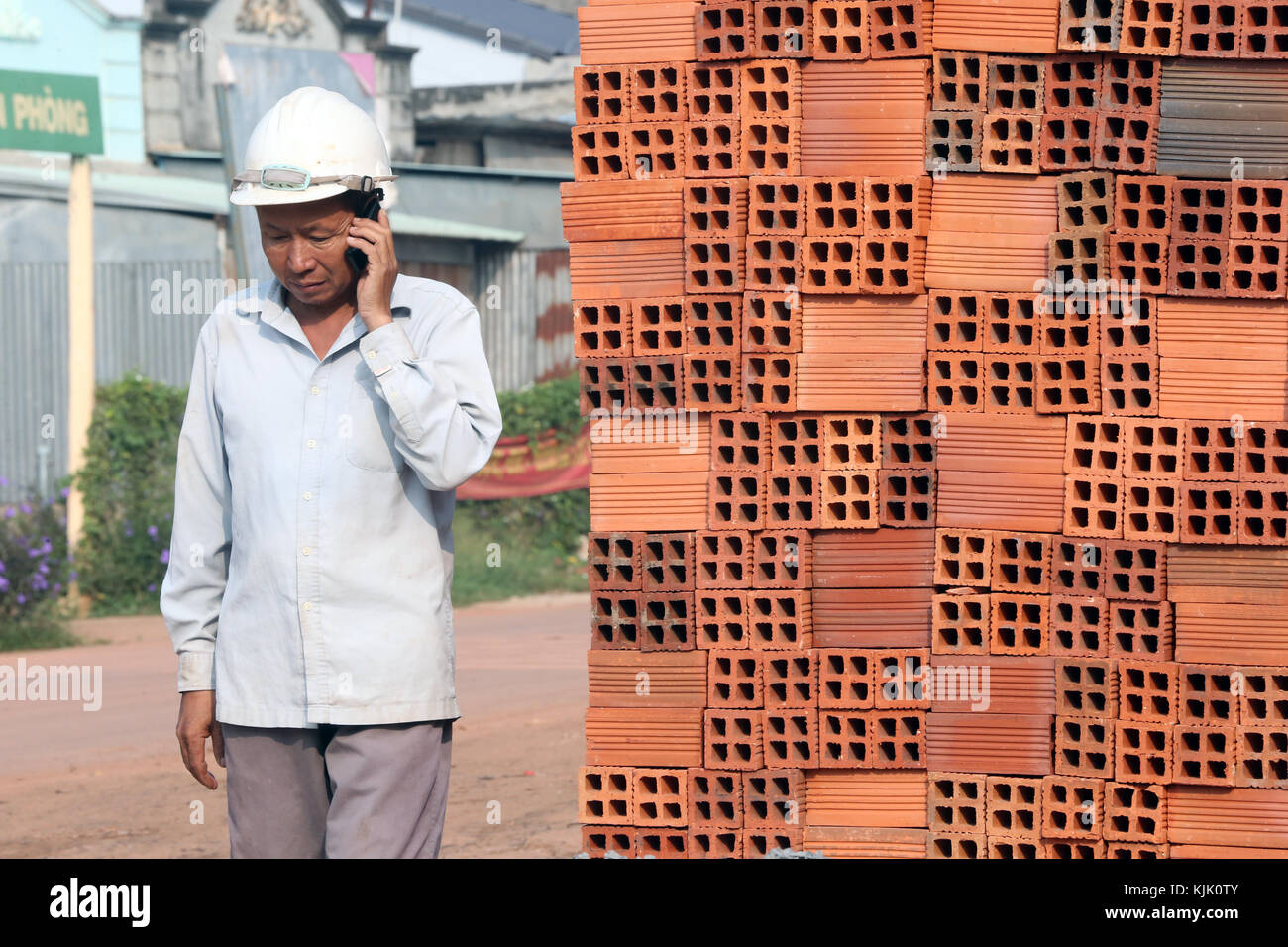 Construction site. Worker using phone.  Thay Ninh. Vietnam. Stock Photo