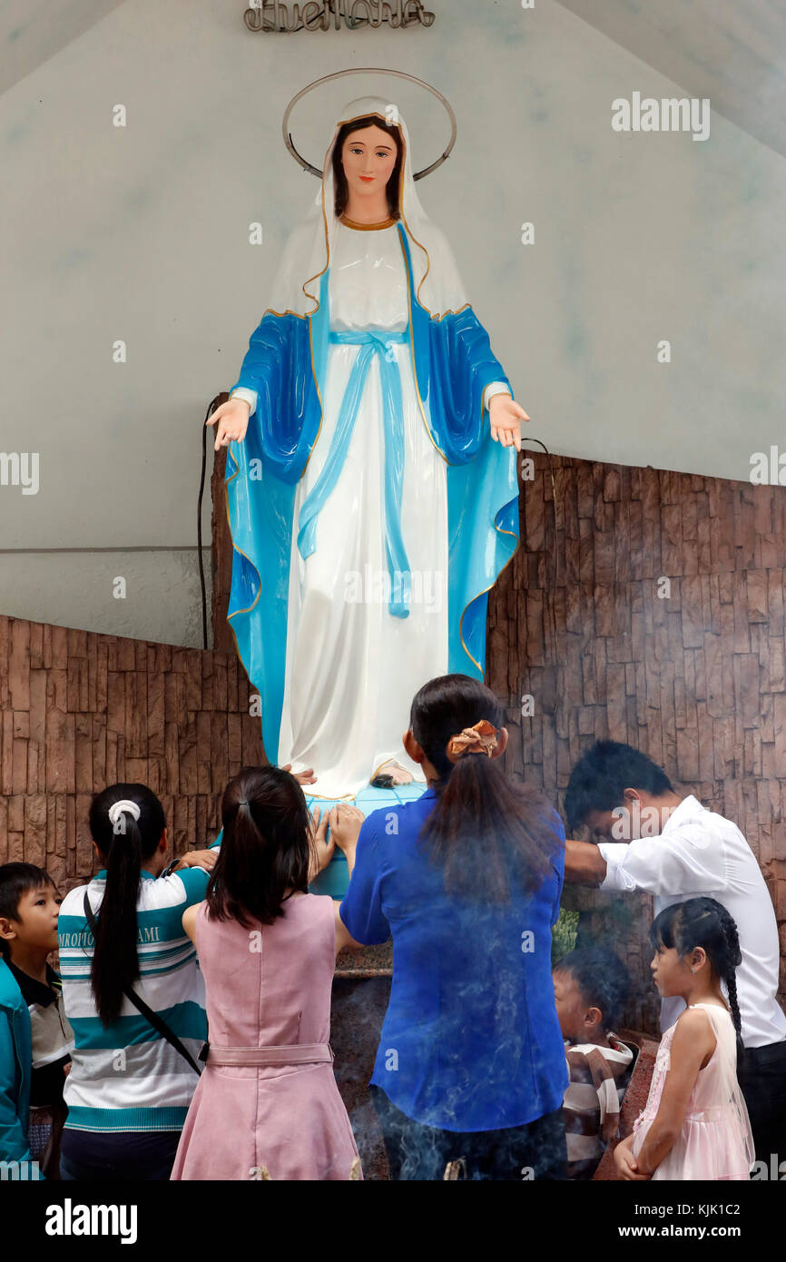 Our Lady of Fatima church.   Catholic family praying the Virgin.  Ho Chi Minh City.  Vietnam. Stock Photo