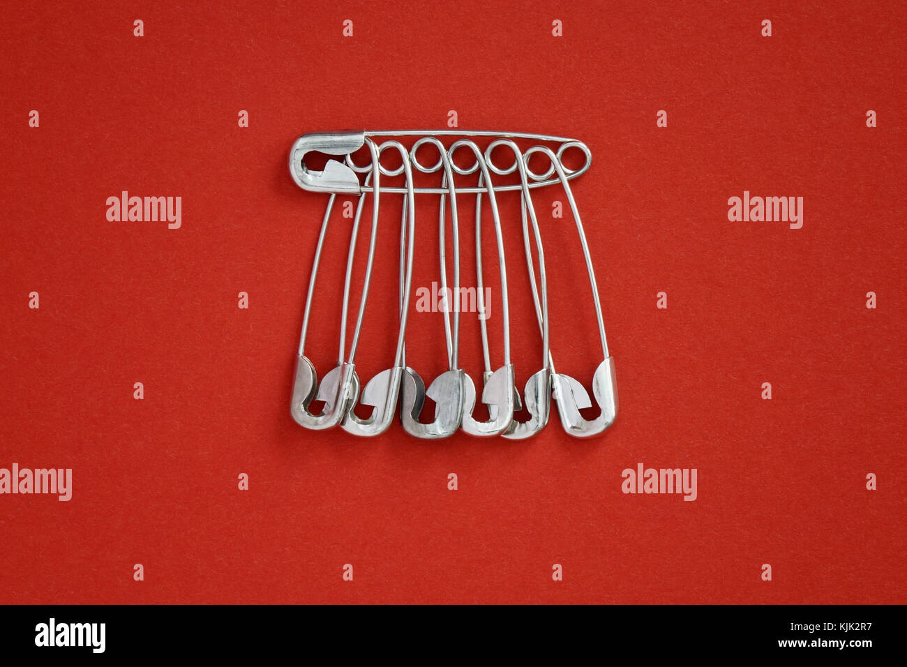 ILLUSTRATION Seven safety pins six of them enclosing the seventh
