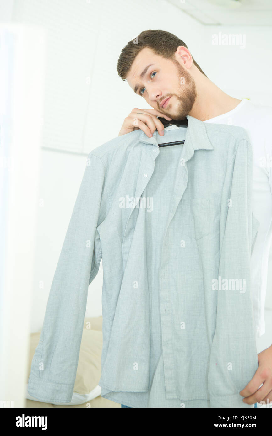 attractive and strong young man choosing shirt Stock Photo - Alamy