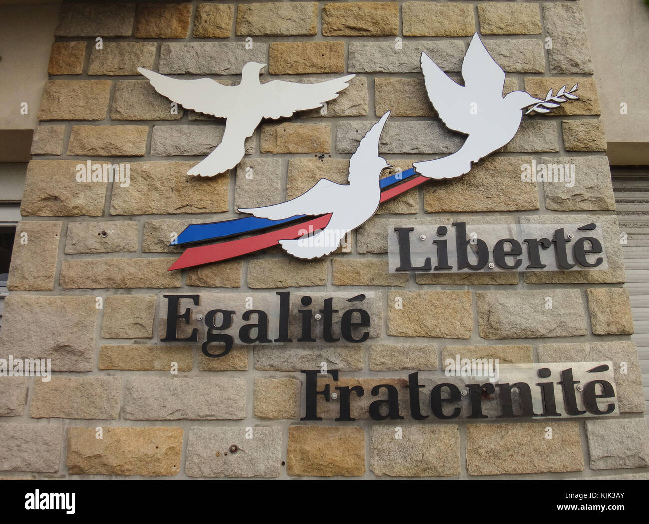 The words Liberté, égalité, fraternité (lit. liberty, equality, fraternity) and peace doves attached to a wall of the town hall in Crozon (France). It is the motto of the current French Republic and was the slogan of the French Revolution of 1789. Photo: Jens Kalaene/dpa-Zentralbild/ZB | usage worldwide Stock Photo