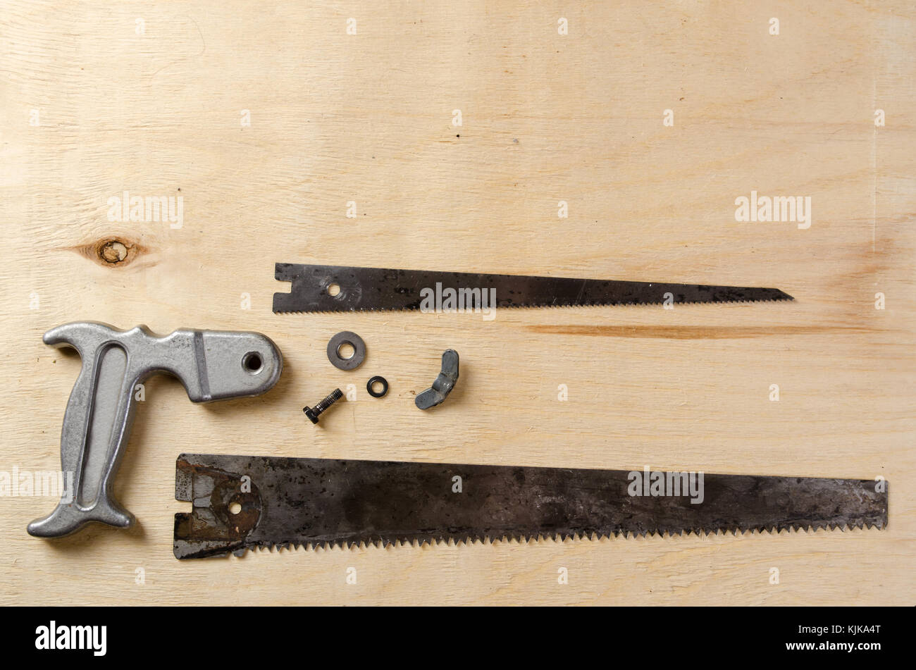 disassemble hand saw lying on a sheet of plywood. flat view Stock Photo