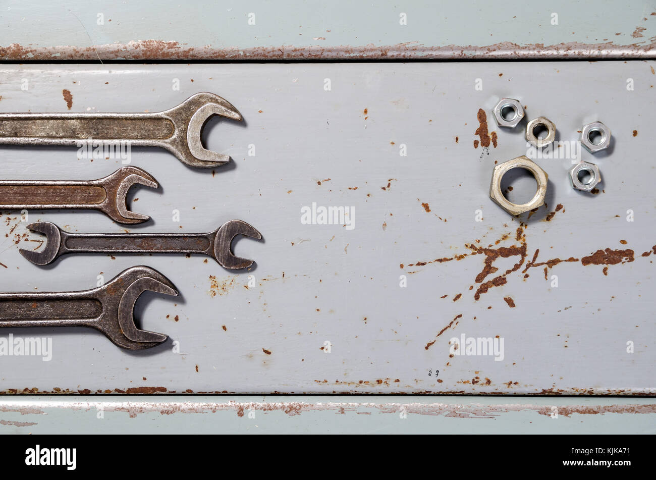 several wrenches and screw-nuts on the painted metal background Stock Photo