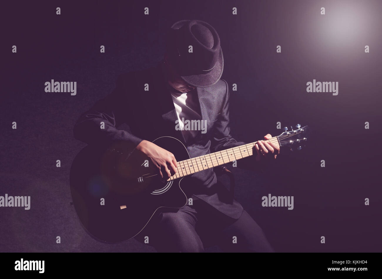 Musician playing the guitar on black background,music concept Stock