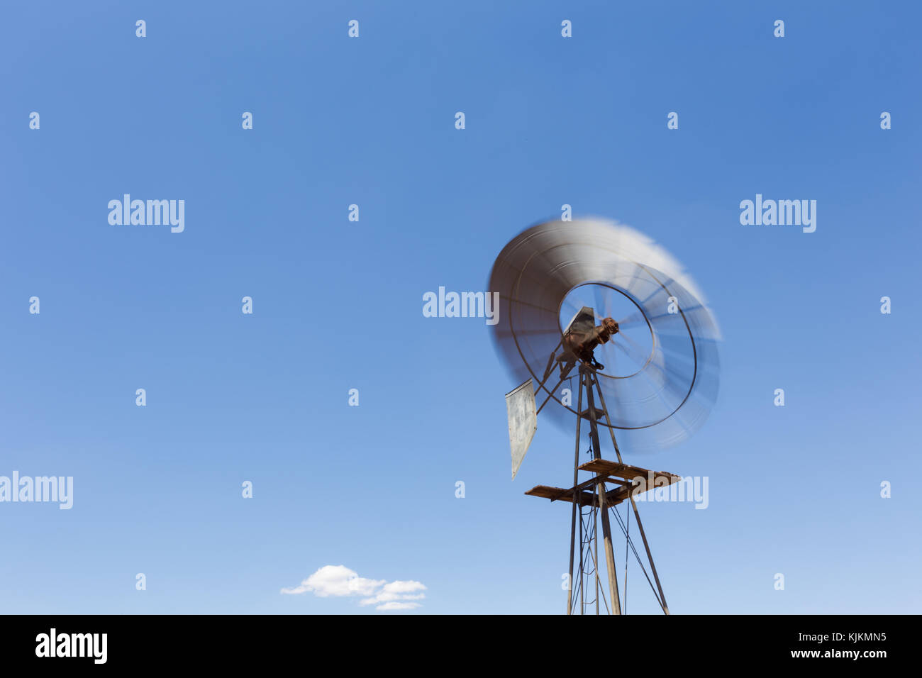 Close up wide angle image of a windmill / windpomp with spinning blades ...