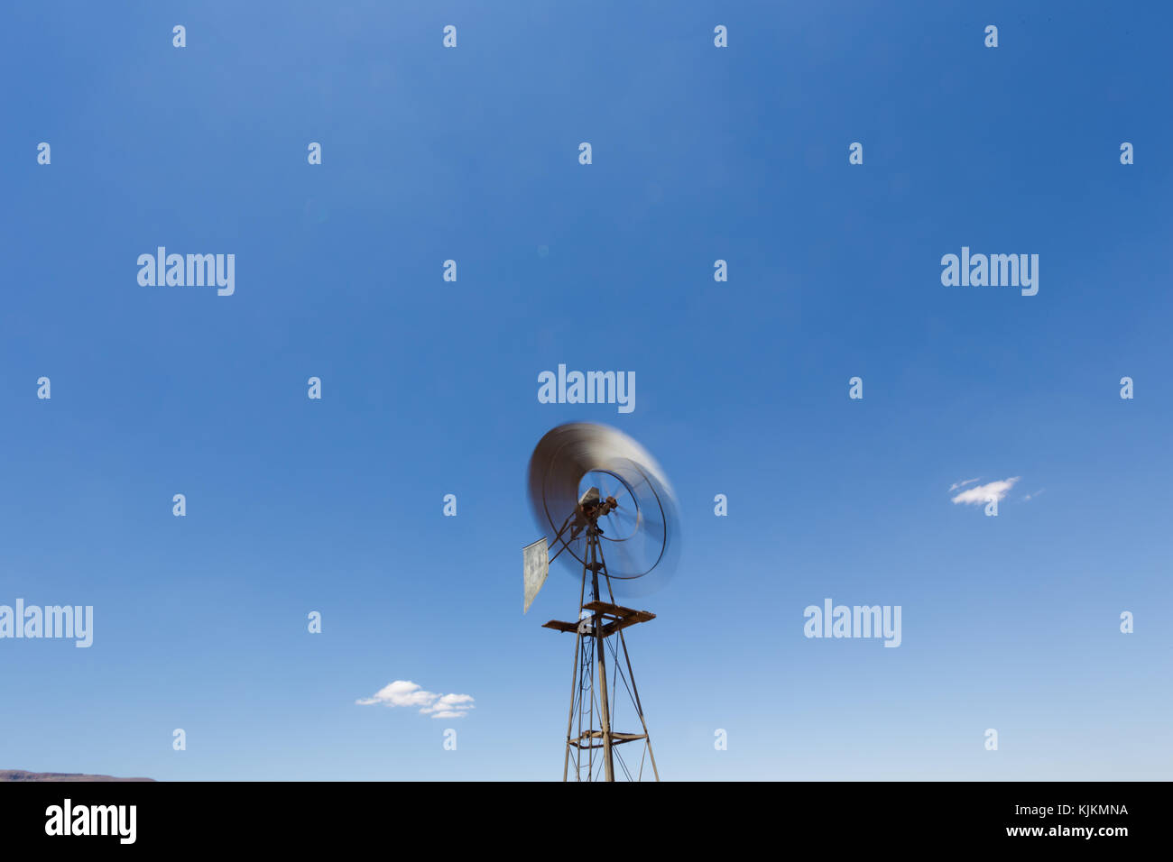 Close up wide angle image of a windmill / windpomp with spinning blades ...