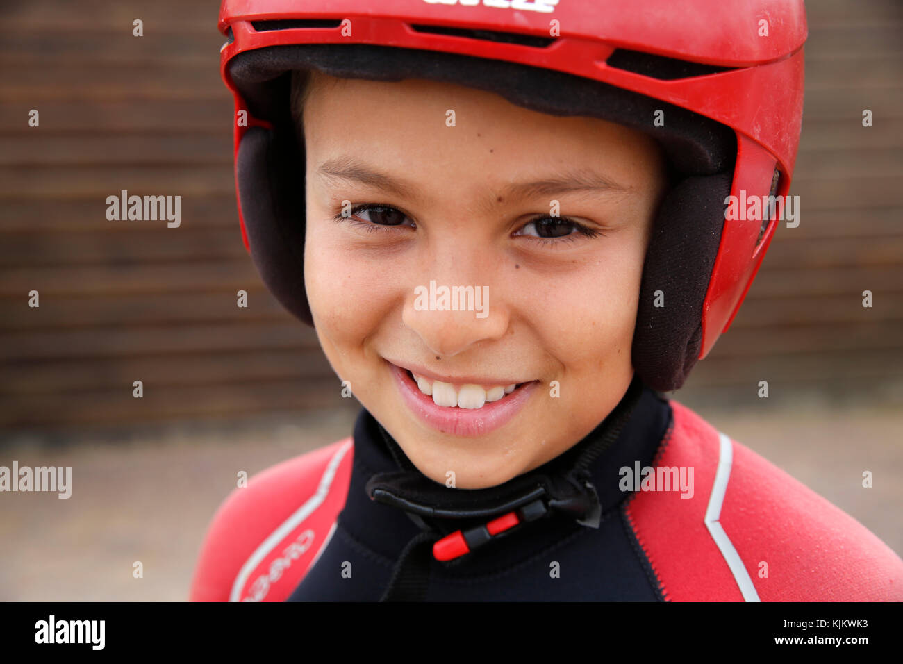 A young caucasian boy wearing rash guard long sleeve swimsuit is