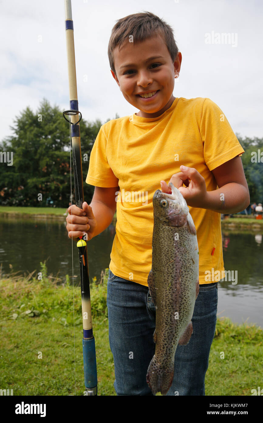Young angler with a freshly caught fish. France. Stock Photo