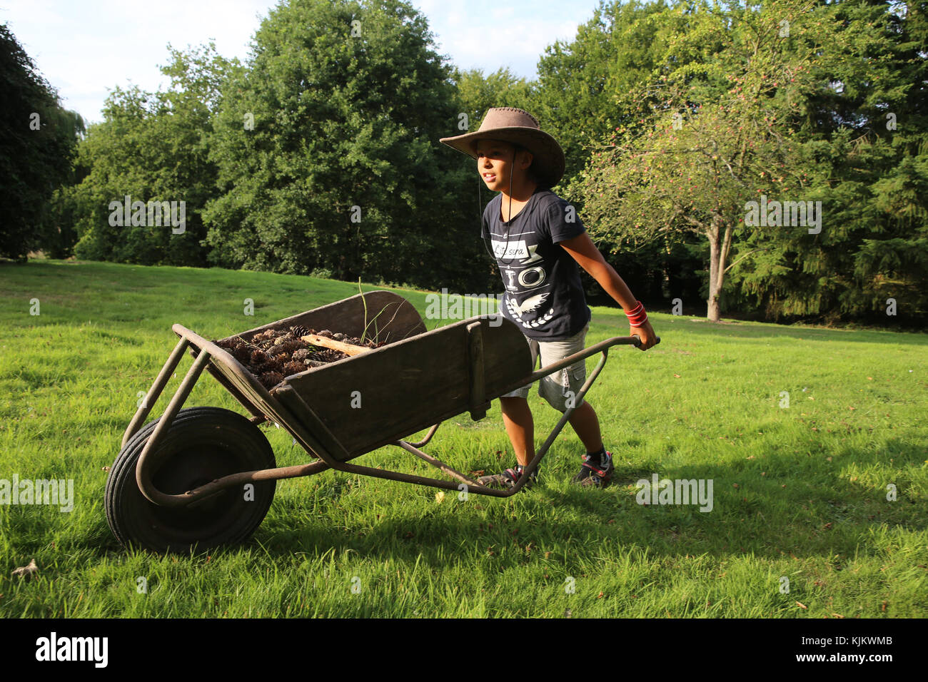 Boy pushing a wheelbarrow. France. Stock Photo