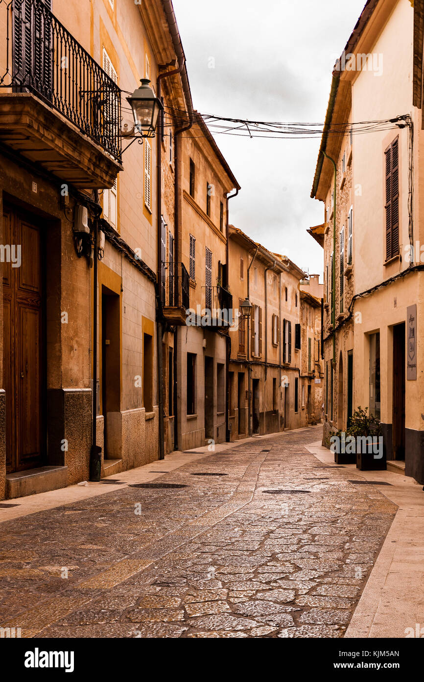 A GORGEOUS,OLD WORLD COBBLED SPANISH STREET IN POLLENCA, MAJORCA, SPAIN. THE NARROW STREETS ARE FULL OF CHARACTER WITH COSY CAFES. Stock Photo