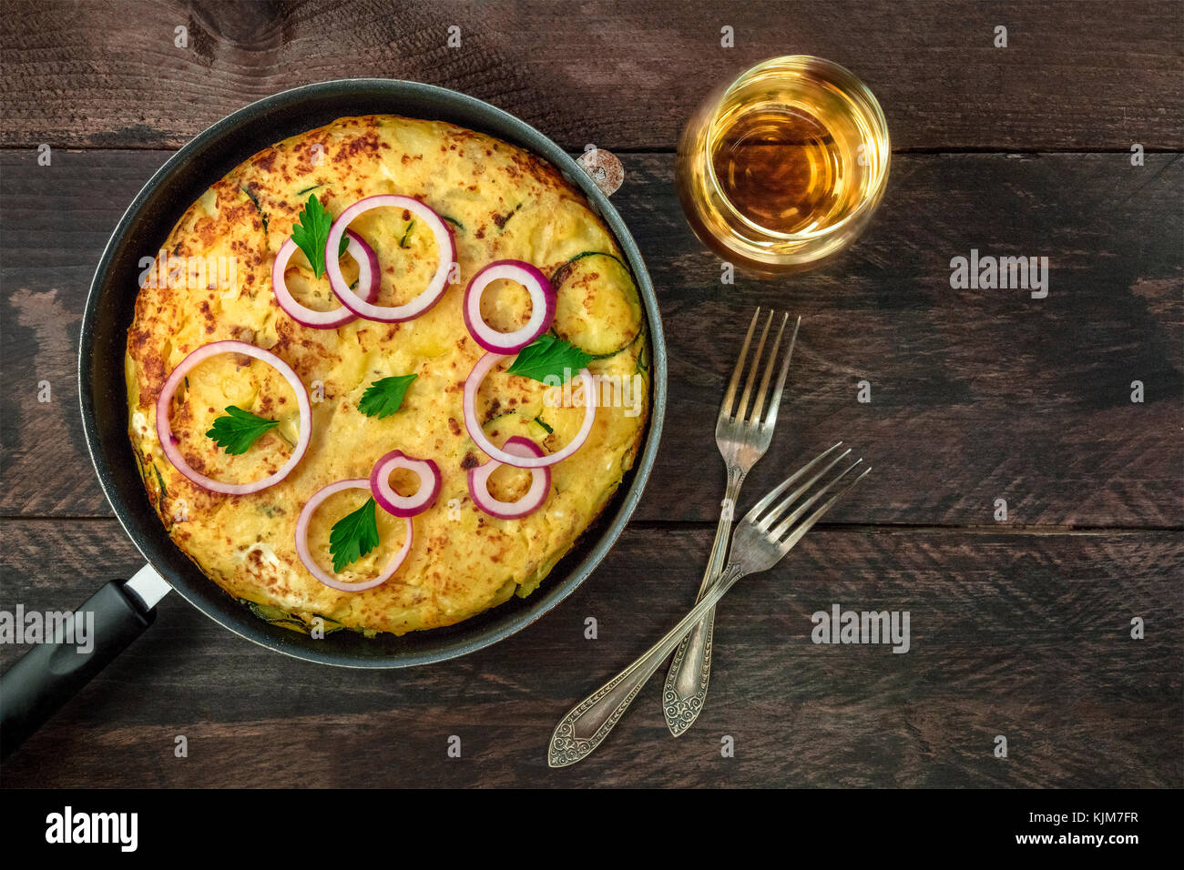 An overhead photo of a Spanish tortilla with potatoes and zucchinis in