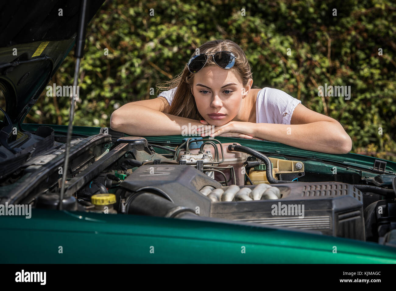 A beautiful young woman looking disappointed because her car has broken down. Stock Photo