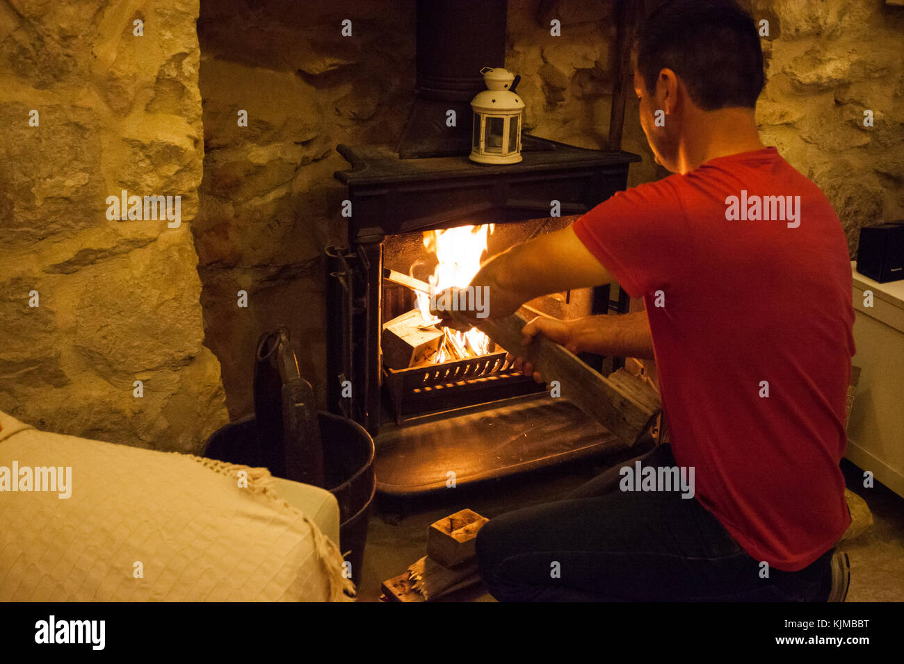 Man starting fire in the fireplace at home. Stock Photo