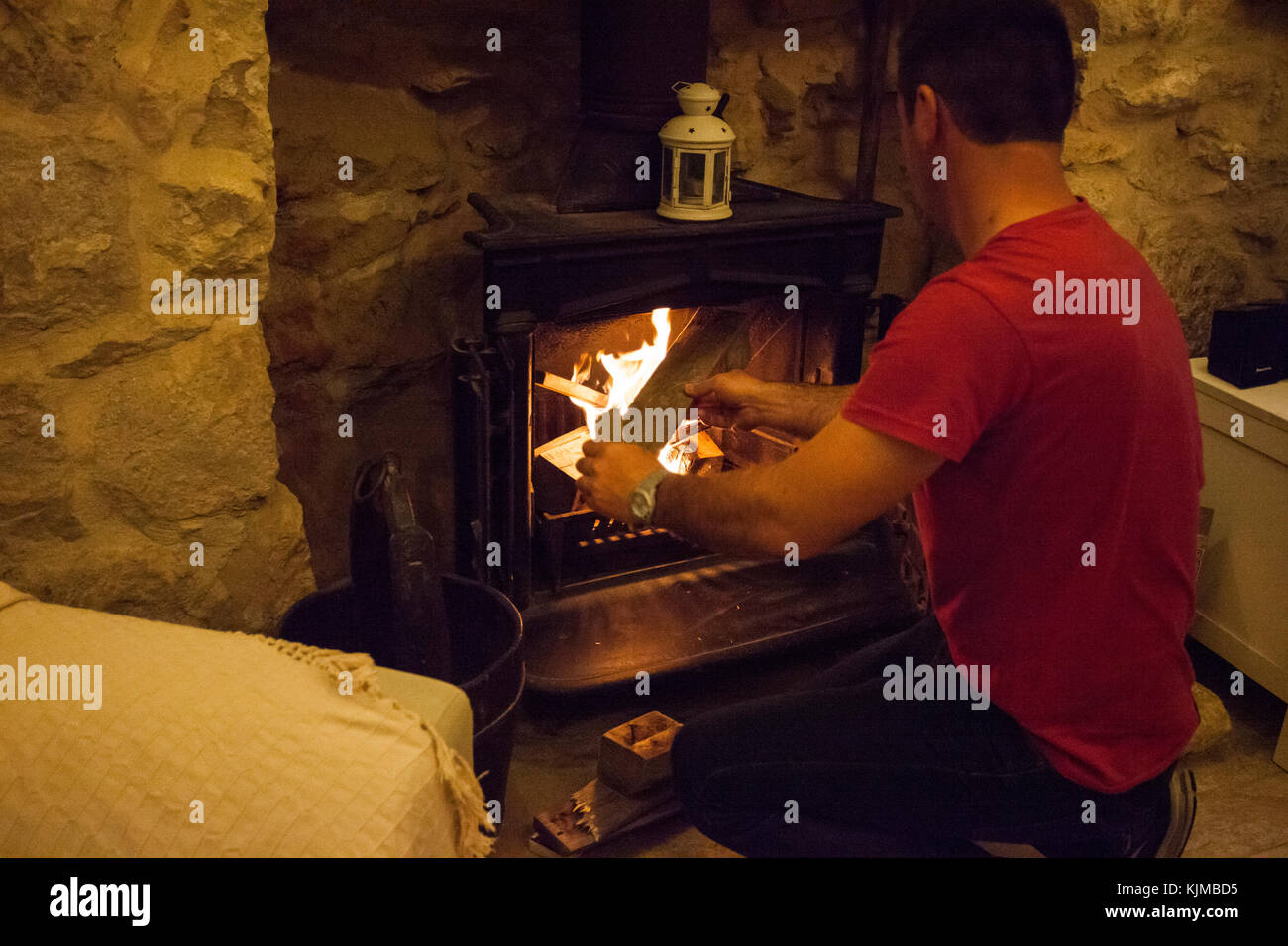 Man starting fire in the fireplace at home. Stock Photo
